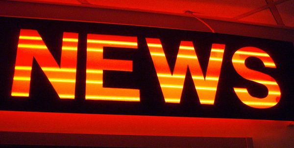A red and orange neon sign with the word "News" all in capital letters